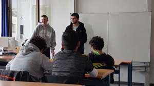 Zwei Schüler der SABEL Fachoberschule München referieren vor ihren Mitschülern zum Thema Bundesdeutscher Vorlesetage